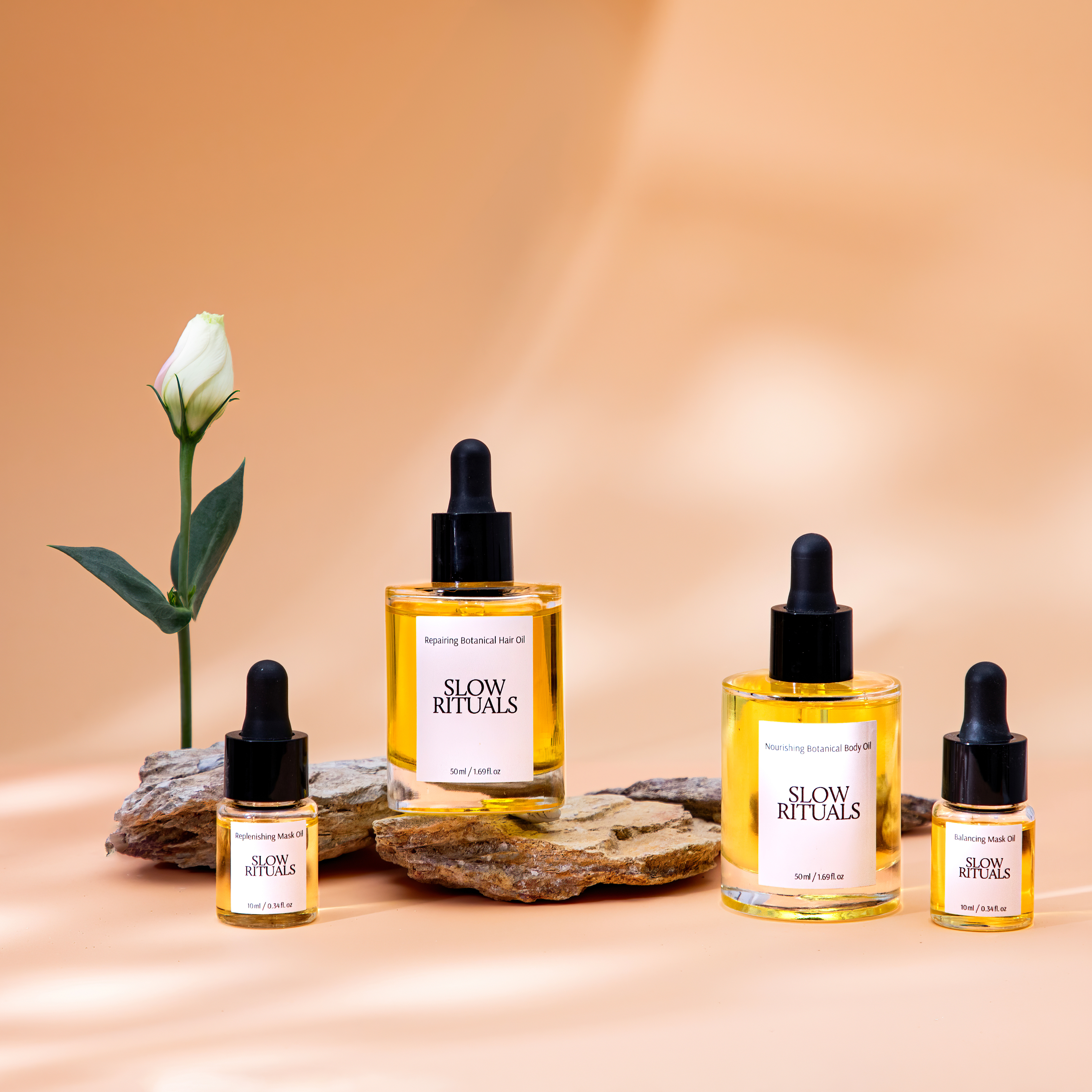 Luxury botanical skincare oil product photography featuring Slow Rituals facial and body oils styled with natural stone props and soft warm lighting. Premium cosmetics photography for ecommerce, beauty campaigns and social media by Productpixels Singapore.