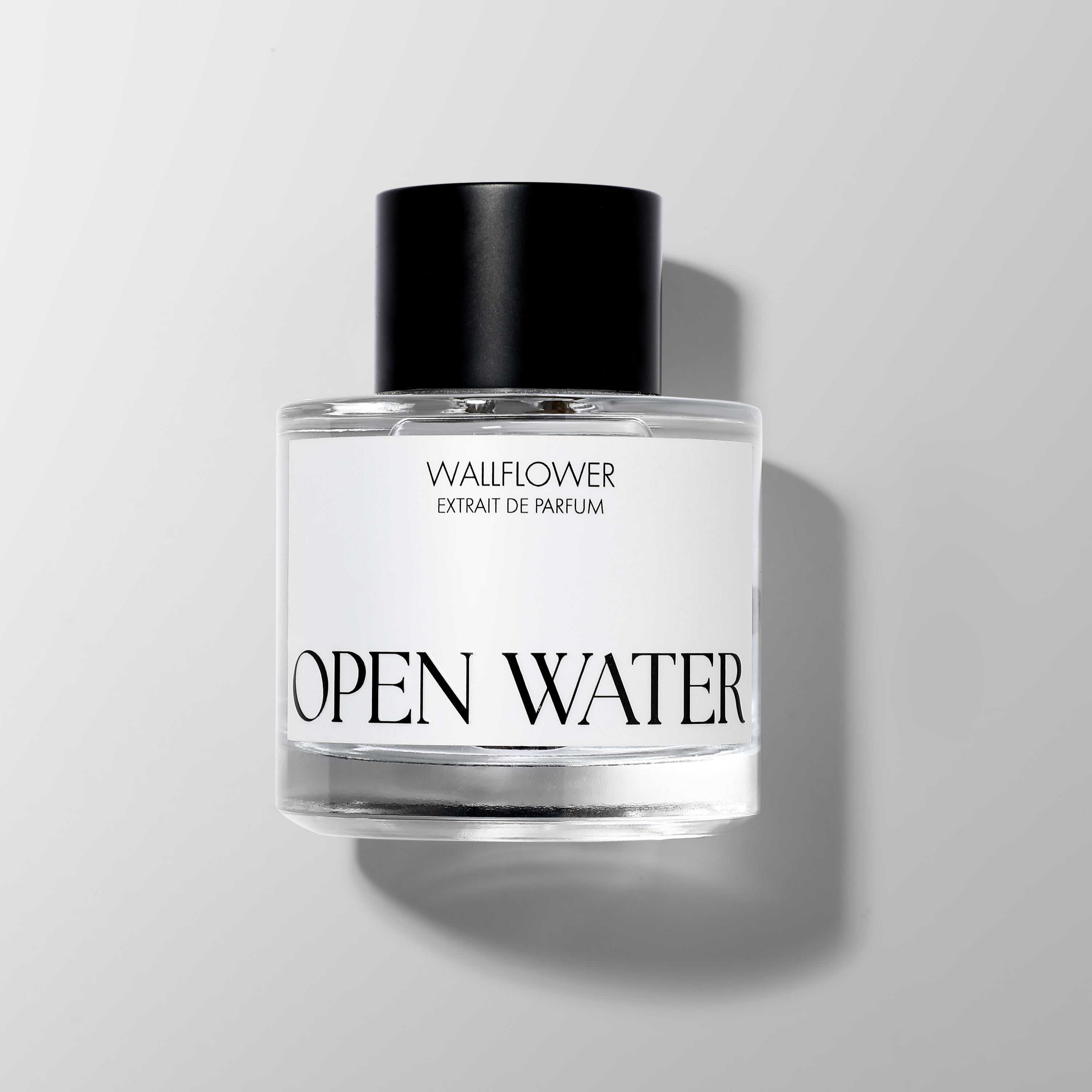 Luxury perfume bottle photography of Wallflower Open Water Extrait de Parfum with soft directional lighting and natural shadows. Premium fragrance product photography for ecommerce, advertising and luxury brand campaigns by Productpixels Singapore.