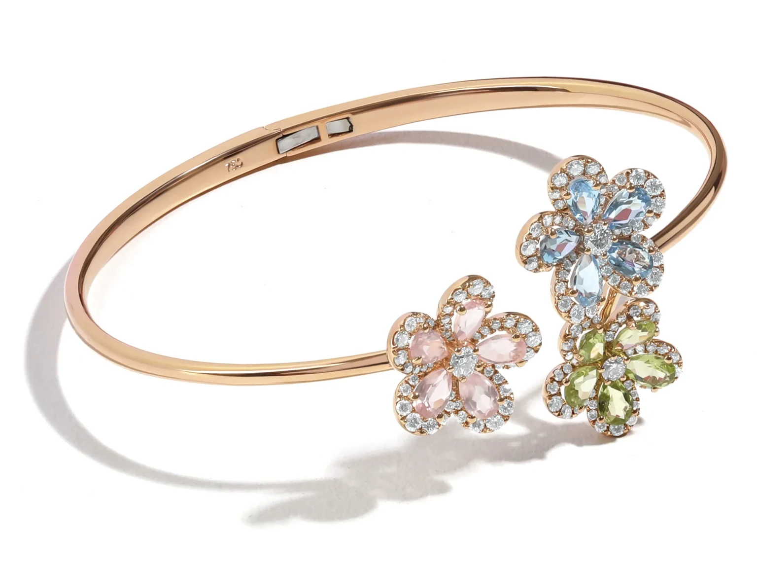 Close-up of a rose gold diamond engagement ring with a pav&eacute; band set in a light beige velvet jewellery box.