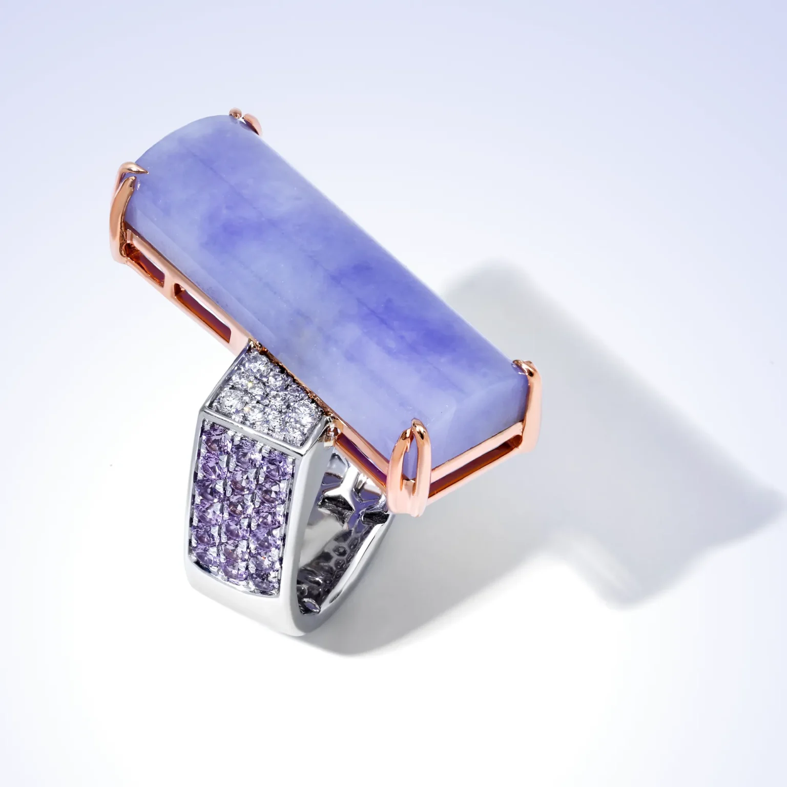 A 9ct blue tanzanite and ruby statement ring set in a carved architectural clear quartz body.