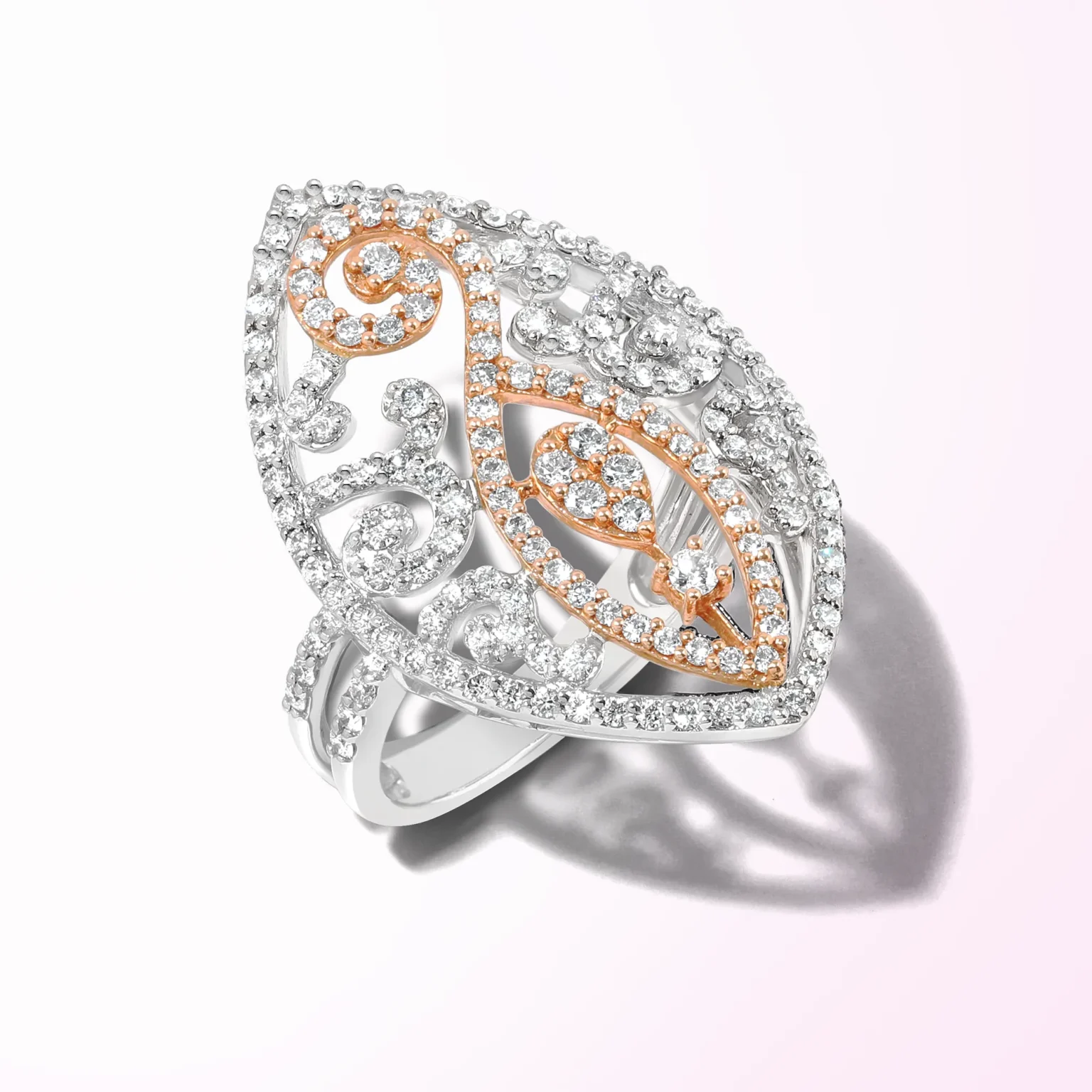 A marquise-shaped white and rose gold filigree ring with intricate diamond pav&eacute; scrolling designs.