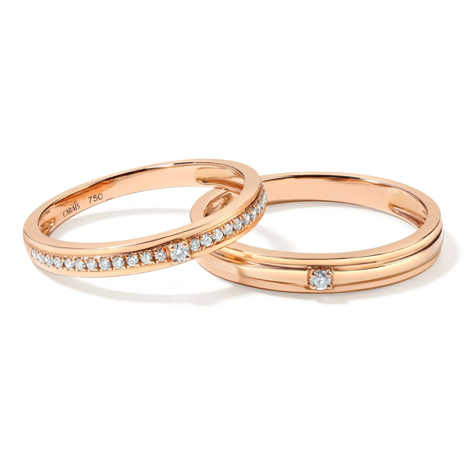 A matching pair of 18K rose gold wedding bands by CARAT'S on a white background, one with multiple diamonds and one with a single center diamond.