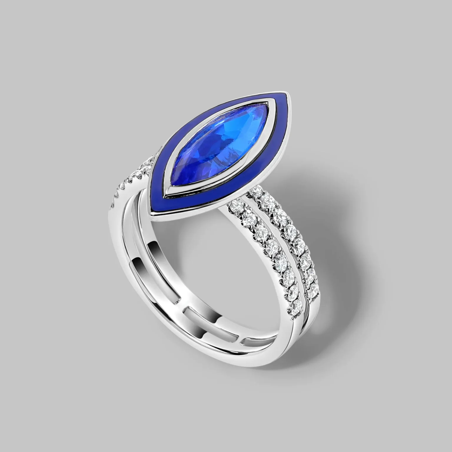 Blue sapphire marquise ring with diamond pav&eacute; band in white gold on grey background.