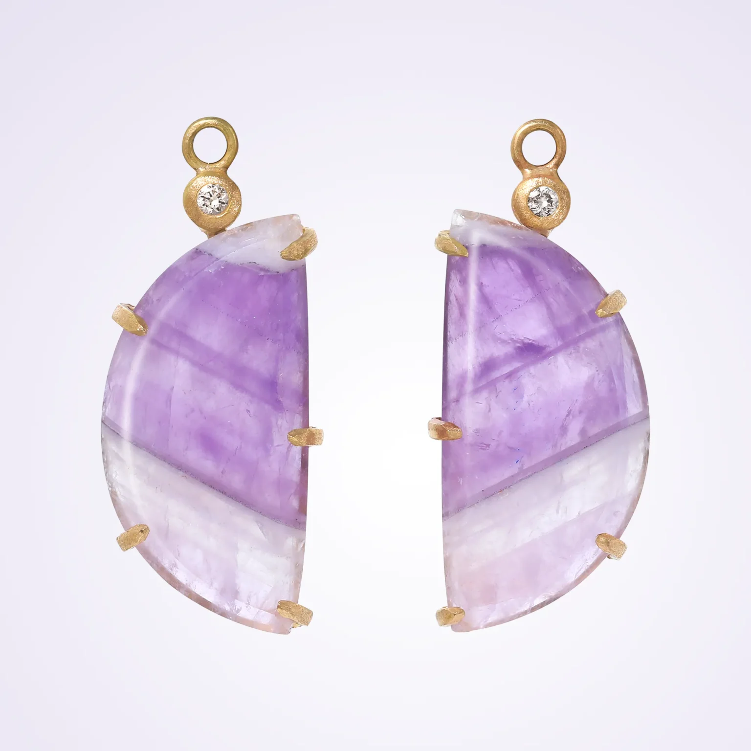 Amethyst slice earrings with gold setting and diamond accents on clean background.
