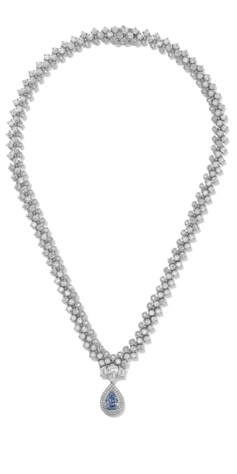 Diamond necklace with pear-shaped blue gemstone pendant on white background.