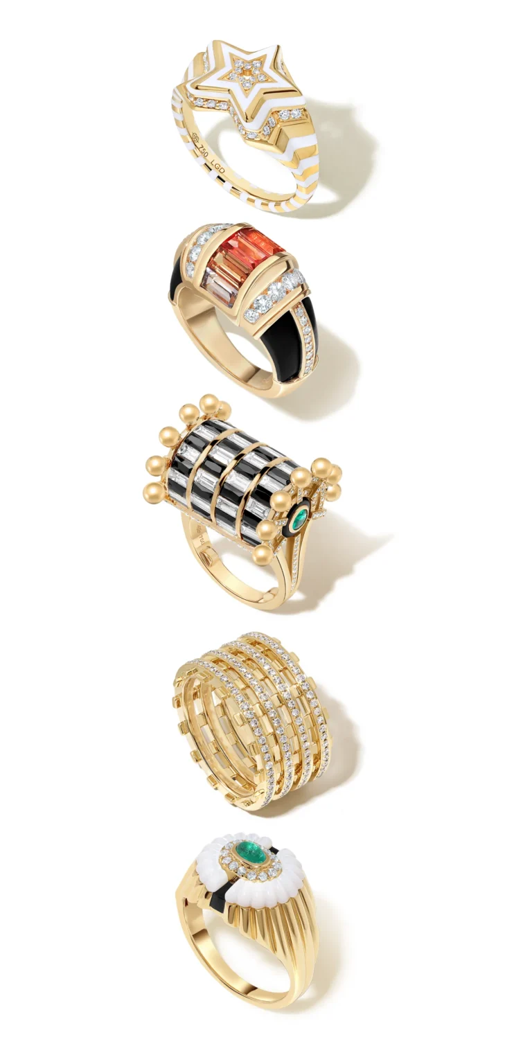 Collection of gold rings with gemstones, enamel and diamond designs on clean background.