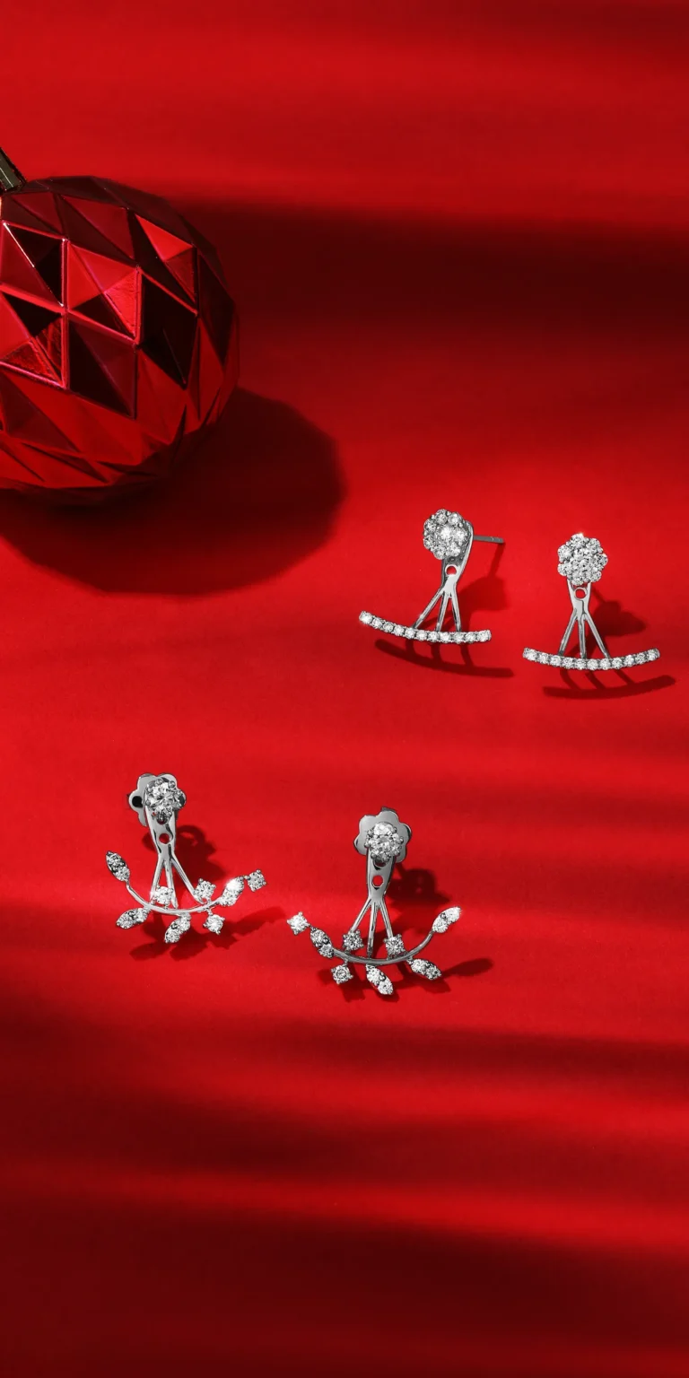 Diamond earrings styled on bold red background with dramatic lighting