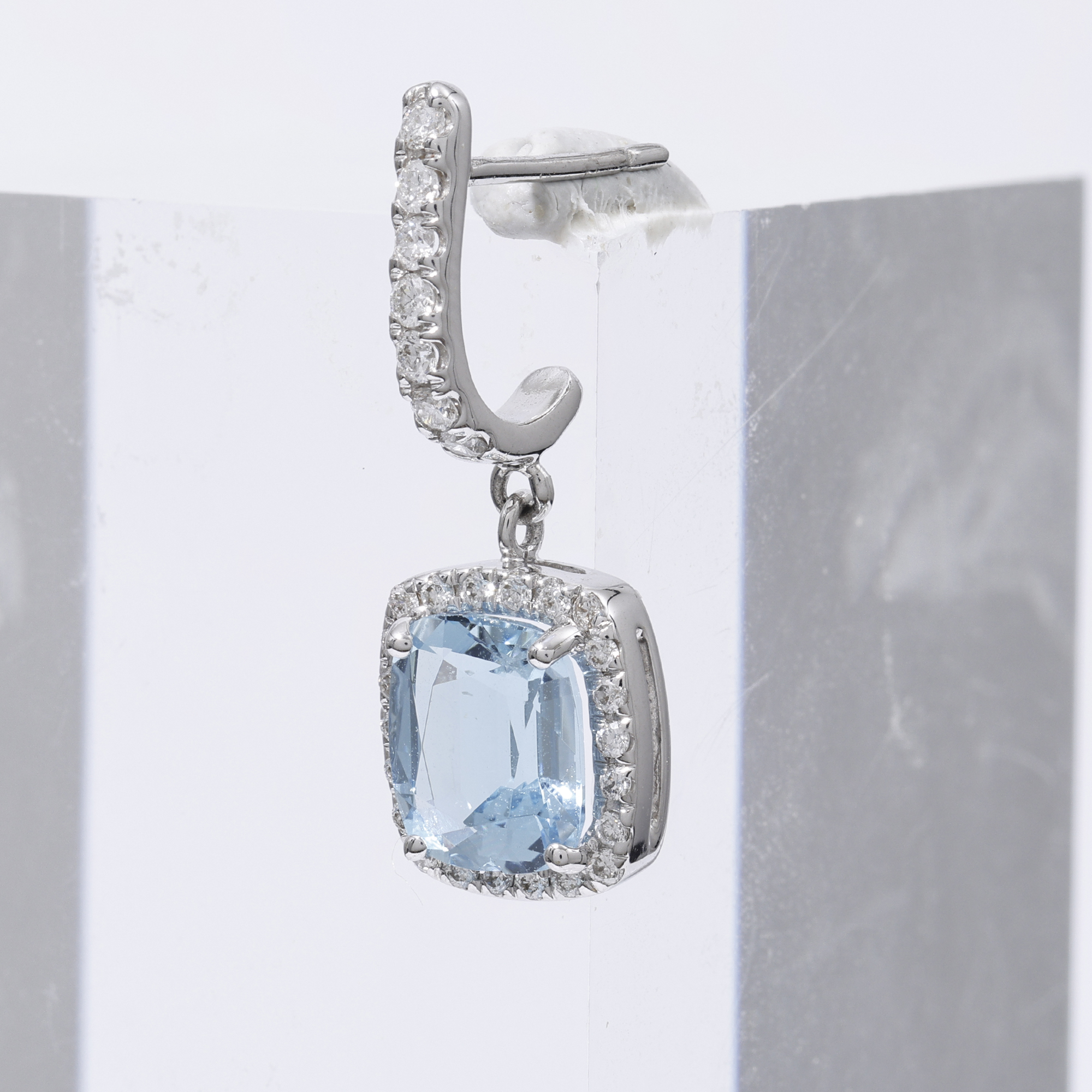 Raw jewellery product image of blue gemstone earring showing imperfections, blue tac support and unclean background before retouching Productpixels Singapore