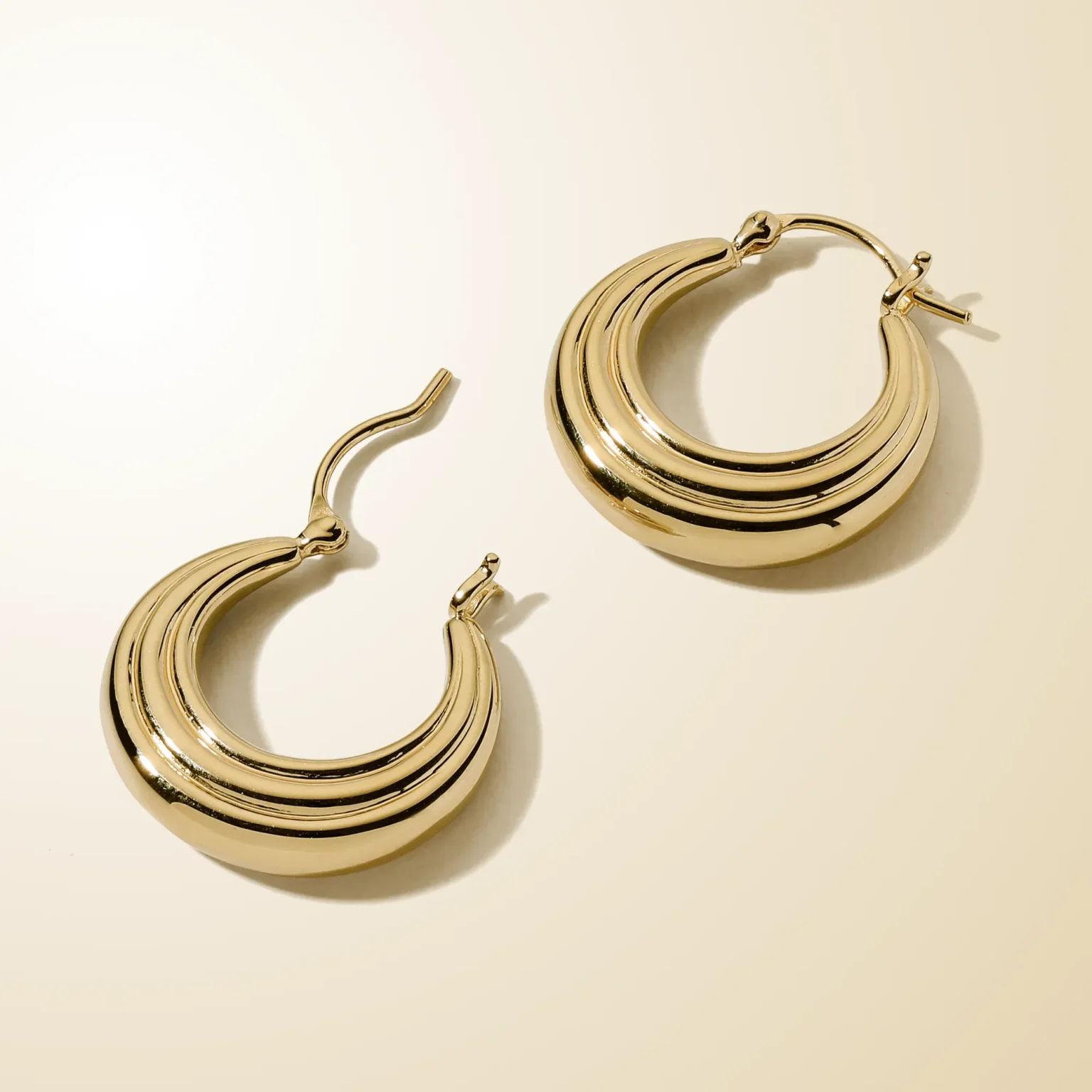 Luxury gold hoop earrings photography featuring polished multi-layer design, captured by ProductPixels Singapore