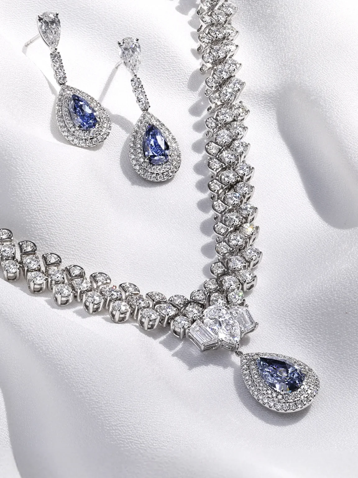 High-end jewellery photography of diamond necklace and sapphire drop earrings highlighting brilliance, colour and fine craftsmanship