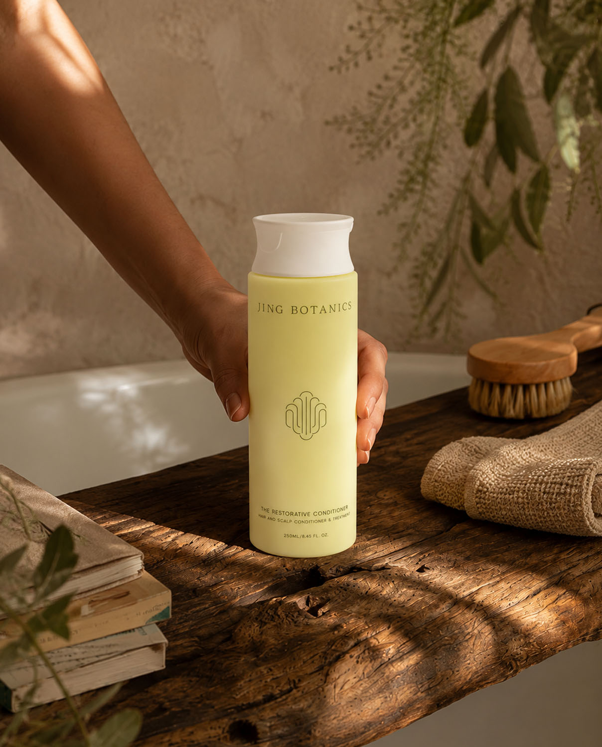 Jing Botanics Restorative Conditioner photographed by Productpixels and placed in an AI-styled natural bathroom setting for a haircare campaign visual.